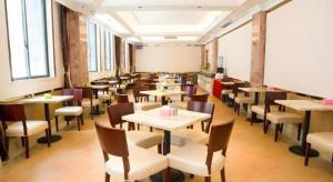 une salle à manger avec tables, chaises et fenêtres dans l'établissement Vienna Classic Hotel Qingyuan Taihe Ancient Cave Scenic Area, à Xiaoshi