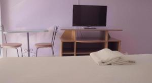 Schlafzimmer mit einem Bett und einem TV auf einem Schreibtisch in der Unterkunft Kumkaew Udon in Udon Thani