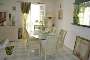 a dining room with a glass table and chairs at La Nicotoria HAUT DE VILLA T4 in Deshaies