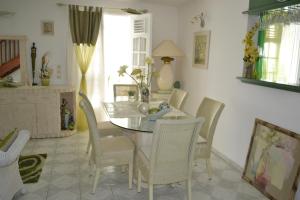 une salle à manger avec une table et des chaises en verre dans l'établissement La Nicotoria HAUT DE VILLA T4, à Deshaies