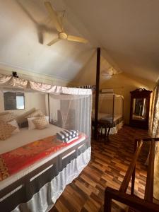 a bedroom with a bed with a ceiling fan at Namaste Beach Huts in Patnem