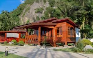 ein kleines Holzhaus vor einem Berg in der Unterkunft Phuphayot Resort in Huai Yot