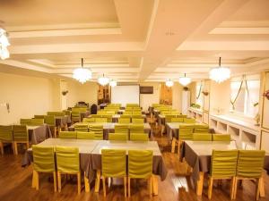 Cette grande chambre comprend des tables et des chaises jaunes. dans l'établissement GreenTree Inn Xi'an Yanta District Dayanta Furongyuan Hotel, à Xi'an