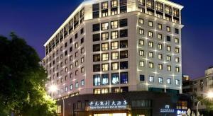 ein großes weißes Gebäude mit Lichtern davor in der Unterkunft New Century Kylie Hotel Ningbo in Ningbo