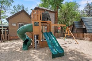 een speeltuin met een glijbaan en een speelhuis bij Timber Lodge #16 in Colorado Springs