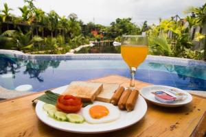 une assiette de nourriture et un verre de bière sur une table dans l'établissement Panwana Resort, à Ban Taphong Nok