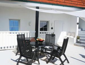 stół z krzesłami i miska owoców na patio w obiekcie Ferienhaus BLACK & WHITE w mieście Bromberg