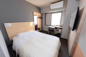 a hotel room with a bed and a desk at Super Hotel Nara Shin Omiya Ekimae in Nara