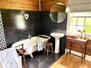 une salle de bain avec une baignoire et un lavabo dans l'établissement Oakchester Cottage on Bruny Island, à Killora 53 autres photos