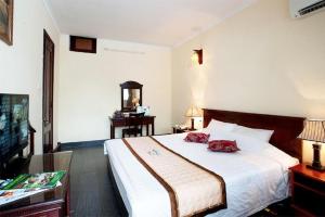a hotel room with a bed and a television at Hai Au Hotel in Ðông Thôn +170 photos