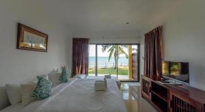 a bedroom with a large bed with a view of the ocean at Villa Phra Chan Resort in Ban Pak Nam Khem Nu