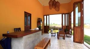 a lobby with a bar and a table and chairs at Villa Phra Chan Resort in Ban Pak Nam Khem Nu