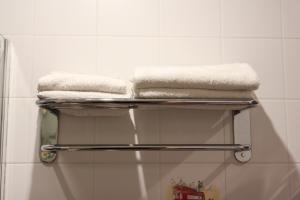 エゴリエフスクにあるDomino Innのバスルームのタオル掛けにタオル2枚
