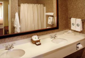 a bathroom with two sinks and a large mirror at Larkspur Landing Folsom-An All-Suite Hotel in Folsom