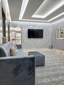 ein Wohnzimmer mit Couch und Flachbildfernseher in der Unterkunft Mountain Park Rest in Ḑab‘ah
