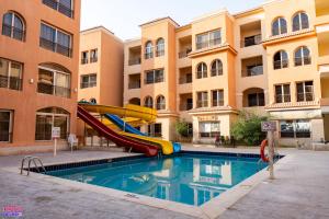 a pool with a slide in front of a building at Rosa Boho Hotel And Aqua Park in Hurghada