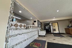 a lobby with a tile wall in a living room at Super 8 by Wyndham Pontiac in Pontiac +18 photos