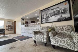 a waiting room with two chairs and a mirror at Super 8 by Wyndham Pontiac in Pontiac