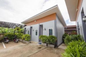 une maison avec une cour ornée de plantes dans l'établissement OYO 1121 Phuree Resort, à Sattahip
