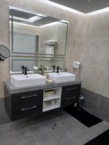 ein Badezimmer mit zwei Waschbecken und einem großen Spiegel in der Unterkunft Mountain Park Rest in Ḑab‘ah