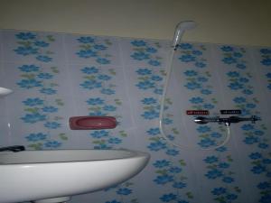 La salle de bains est pourvue d'une douche avec des fleurs bleues sur le mur. dans l'établissement Wattana Hill Resort, à Ban Tao Than