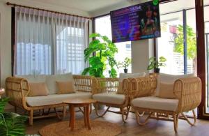 ein Wohnzimmer mit Korbstühlen und einem Fernseher in der Unterkunft Chiangkhan Town Hotel in Chiang Khan