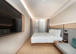 Ένα ή περισσότερα κρεβάτια σε δωμάτιο στο JI Hotel Shanghai Xietu East Road