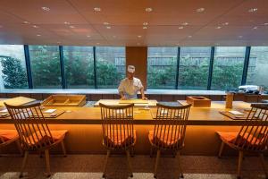 a man standing at a table in a restaurant at Hyatt Regency Hakone Resort and Spa in Hakone
