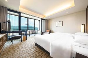 a hotel room with a large white bed and a desk at Hyatt Regency Hakone Resort and Spa in Hakone +80 photos