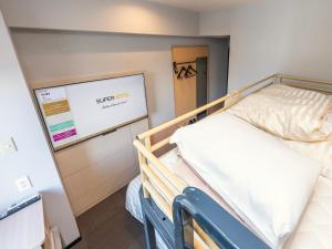 a hospital bed in a room with a sign on the wall at Super Hotel Nara Shin Omiya Ekimae in Nara