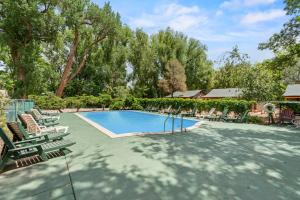 een zwembad met ligstoelen en een huis bij Timber Lodge #1 in Colorado Springs