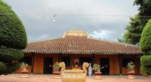 a building with a tiled roof with a fountain in front of it at A&Em Signature Hotel in Ho Chi Minh City