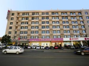 un grand bâtiment avec des voitures garées devant dans l'établissement Jinjiang Inn JiNan Daminghu New Scenic Area Lishan Road, à Jinan