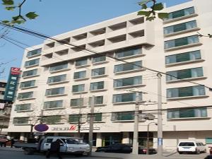 a large white building with cars parked in front of it at Magnotel Business Xuzhou Jinying Sudi Road Metro Station in Xuzhou