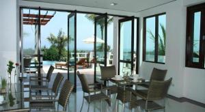 ein Esszimmer mit einem Tisch, Stühlen und einem Pool in der Unterkunft Grand Hill Residence in Ban Tai