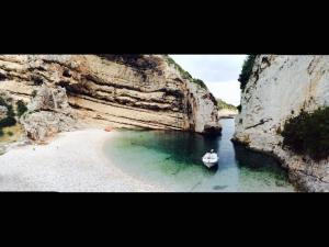a small boat in the water next to a beach at Holiday home Stiniva in Vis