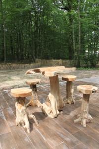 a picnic table made out of tree stump logs at L'isba des bois, hors du temps in Janvry