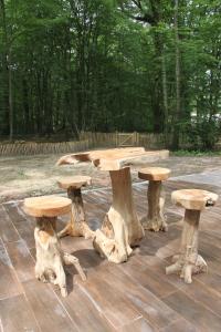 une table de pique-nique en rondins d'arbre dans l'établissement L'isba des bois, hors du temps, à Janvry