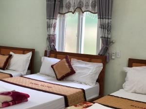 ein Zimmer mit zwei Betten und einem Fenster in der Unterkunft Rose Hotel in Cừ Lạc