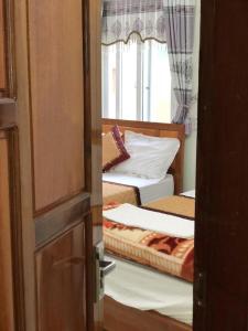 Zimmer mit 2 Betten, einem Fenster und einer Tür in der Unterkunft Rose Hotel in Cừ Lạc