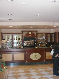 a woman standing in front of a bar at Hotel San Giorgio in San Nicola Arcella