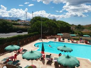 a swimming pool with chairs and umbrellas at Hotel San Giorgio in San Nicola Arcella