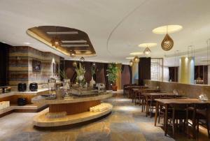 ein Restaurant mit Tischen und Stühlen und eine Bar in der Unterkunft Jinjiang Metropolo Hotel - Liyang Tianmu Lake in Liyang