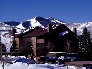 a building covered in snow with mountains in the background at PowderWood in Kimball Junction