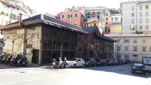 un edificio su una strada cittadina con moto e auto di Il Riposo del Guerriero Guesthouse a Genova