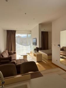 a living room with a couch and a television at Budva Wow 503 in Budva
