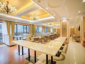 a large dining room with white tables and chairs at Vienna Hotel Guangxi Liuzhou Xijiang Vientiane City in Liuzhou
