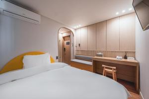 une chambre d'hôtel avec un lit, un bureau et une sidx dans l'établissement Gyeongju Hotel Gonggan, à Gyeongju