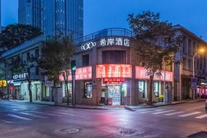ein Gebäude mit Neonschildern an der Straßenseite in der Unterkunft Xana Hotelle· Tianjin Railway Station Jinwan Square Binjiang Avenue in Tianjin