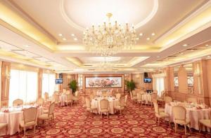 a banquet hall with tables and chairs and a chandelier at Excemon Beach Hotel Beihai in Beihai +277 photos
